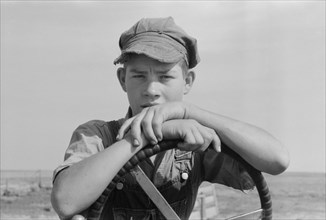 Son of Mr. Germeroth, FSA Client, Portrait Sitting at Steering Wheel of Tractor, Sheridan County, Kansas, USA, Russell Lee, Farm Security Administration, August 1939