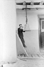 Man Ringing Bell with Rock, Church of the Twelve Apostles, Trampas, New Mexico, USA, Russell Lee, Farm Security Administration, July 1940