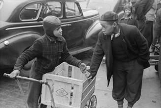 Two Boys Standing in front of Grocery Store Waiting for Jobs to Cart Home Groceries of Shoppers, South Side, Chicago, Illinois, USA, Russell Lee, Farm Security Administration, April 1941