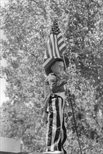 Young Boy in Patriotic Costume Waving American Flag during Fourth of July Parade, Vale, Oregon, USA, Russell Lee, Farm Security Administration, July 1941