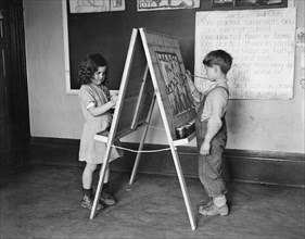 Boy and Girl Painting on Classroom Easel, Reedsville, West Virginia, USA, Elmer Johnson, Farm Security Administration, April 1935