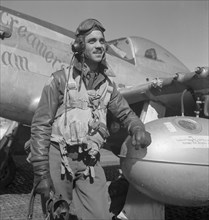 Tuskegee Airman Edward C. Gleed of Lawrence, Kansas, Class 42-K, Group Operations Officer, Three-quarter Length Portrait, Wearing Flight Gear, with Left Arm Resting on Airplane at Air Base, Ramitelli,...