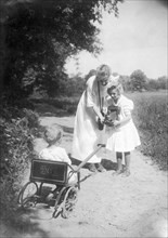 Mother Helping Daughter Take Photo of Baby with Kodak Folding Camera, circa 1911