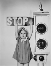 Shirley Temple, Holding Hands Up Against Stop Sign, Portrait, 1934