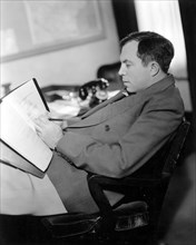 Director King Vidor reading the script of the Film, "The Texas Rangers" in his office, 1936