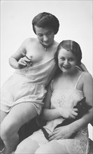 Two Women Wearing Lingerie, One Holding a Cigarette, the Other a Cat, circa 1925