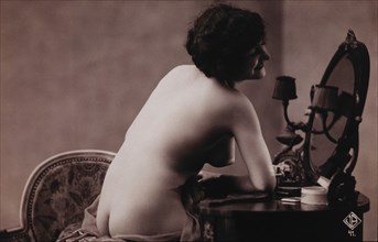 Smiling Nude Woman Looking in Table Mirror, circa 1910's