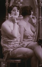 Lingerie Model Seated Beside Mirror Holding a Cigarette, circa 1920