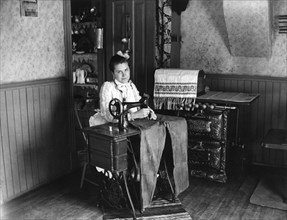 Woman Sewing Pants on Sewing Machine, circa 1905