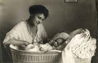 Woman Sitting next to Infant in Bassinet, Portrait, circa 1920