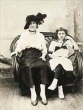 Woman in Black Hat with Teenage Girl in Sailor Outfit Sitting on Rattan Chair, Portrait, circa 1910