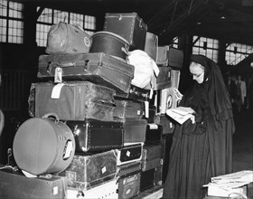 Roman Catholic Sister with Luggage Waiting  to Board SS Normandie While Ship is Being Inspected due to Pending War Crisis in Europe, New York City, USA, 1939