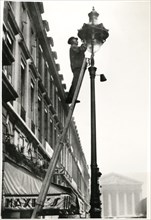 Workman Placing Special Light Diminishing Apparatus on Street Light as Necessary Precaution due to Pending War Crisis in Europe, Paris, France, August 1939