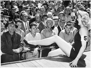 All-Male Crowd Watching Contestant in one-piece Bathing Suit Perform during Beauty Contest, Los Angeles, California, USA, 1943