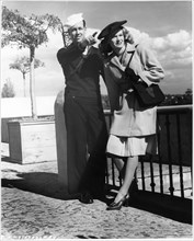 Actress K.T. Stevens Modeling Coat While Standing next to Pointing Sailor during World War II, 1944