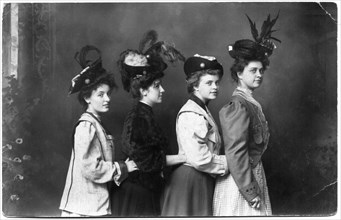 Four Fashionable Women in Feathered Hats Standing in Row with Hands Touching Waists, Portrait, circa 1915
