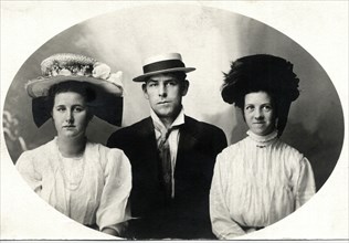 Two women Flanking Man, All in Hats, Portrait, circa 1909