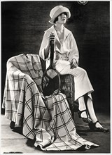 Fashionable Young Woman in White Jersey Sport Costume with Plaid Coat-Cape, Holding Tennis Racquet, Portrait, circa 1922