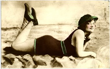 Smiling Woman in One-Piece Swimsuit and Cap Laying on Ground with Hand under Chin, Portrait, Postcard, circa early 1900's