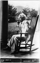 Samuel Langhorne Clemens, or better known as Mark Twain (1835-1910), American Writer and Humorist, Portrait in Rocking Chair Smoking Cigar, circa 1908