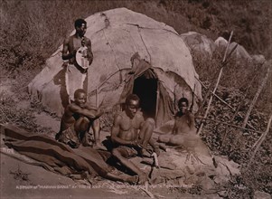 Group of Zulus in Front of Hut, Elder Zulu Cutting Knobkerrie, Africa, circa 1890