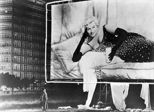 Man Looking up at Anita Ekberg on billboard, on-set of the Film, "Boccaccio '70", 1962