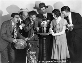 Harry Green, (holding ticker tape), Mary Brian, Neil Hamilton, on-set of the Film, "The Kibitzer", 1930