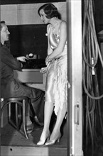 Corinne Griffith, with sound engineer in booth, on-set of the film, "Lilies of the Field", 1930