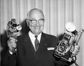 Former U.S. President Harry S. Truman, Smiling Portrait Holding Two Cameras, June 1960