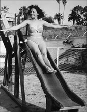Actress Charlita, Publicity Portrait on Slide in Two-Piece Bathing Suit, circa 1955