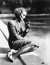 Actress Marlene Dietrich Sitting by Pool and Smoking, 1932