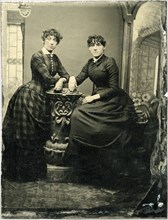 Portrait of Two Adult Women, One Seated, Both Leaning on Short Pillar, circa 1870