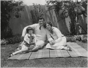 Actor George Bancroft, Portrait Sitting on Blanket with Wife Octavia Broske and Daughter Georgette, Santa Monica, California, USA, 1920's