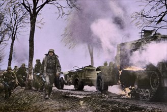 Enemy Troops Passing Burning U.S. Equipment, Ardennes-Alsace Campaign, Battle of the Bulge,1945