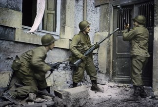 Infantrymen Battle Down Door of House where German Snipers are Holding Out, Stavelot, Belgium, Ardennes-Alsace Campaign, Battle of the Bulge, December 1944