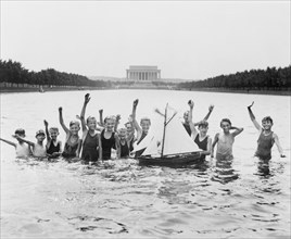 Group of Boys Waving at Camera while Playing with a Toy Sailboat in Reflecting Pool in front of Lincoln Memorial, Washington DC, USA, National Photo Company, July 7, 1926