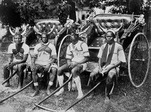 Four Young Men Wearing Headdresses Sitting with Two Rickshaws, Durban, South Africa, 1890's