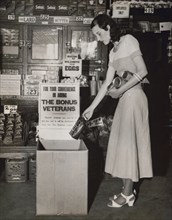 Miss Mary Wick Placing Bag of Coffee in Food Box placed in Stores to Receive Contributions for Encamped Bonus Army Veterans, Washington DC, USA, Underwood and Underwood, June 1932