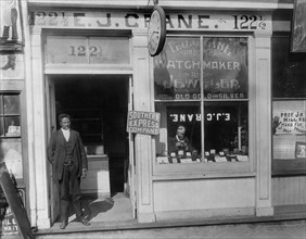 Man Working in Window and Man Standing in Doorway, E.J. Crane Watchmaker and Jewelry Store, Richmond, Virginia, USA, 1900
