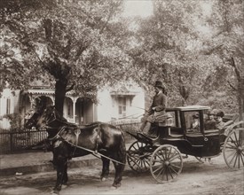 David Tobias Howard, an Undertaker, his mother, and wife, Seated in Horse-drawn Carriage with Tree-shaded House in Background, Atlanta, Georgia, USA, W.E.B. DuBois collection, 1900