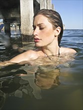 Young Woman in Water Near Pier, Portrait