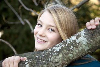 Smiling Girl Holding Tree Limb