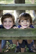 Smiling Boys Resting Chins on Wooden Step