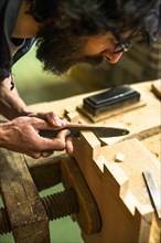 Woodworker Using Rasp on Piece of Wood, High Angle View