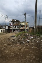 Poor Neighborhood With Pile of Garbage on Dirt Street, Medellin, Colombia