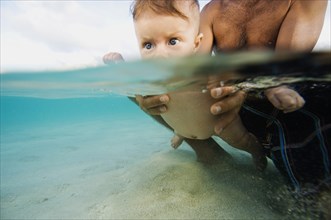 Mid-Adult Man with Baby in Ocean Water