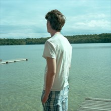 Young Man Looking at Lake From Dock