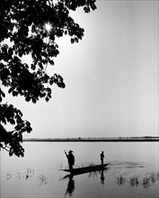 Two Men in Canoe Fishing on River