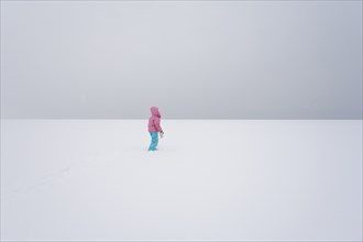 Lone Girl in Vast Snowy Field