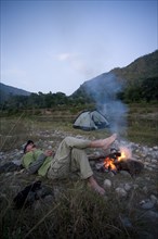 Man Resting by Campfire